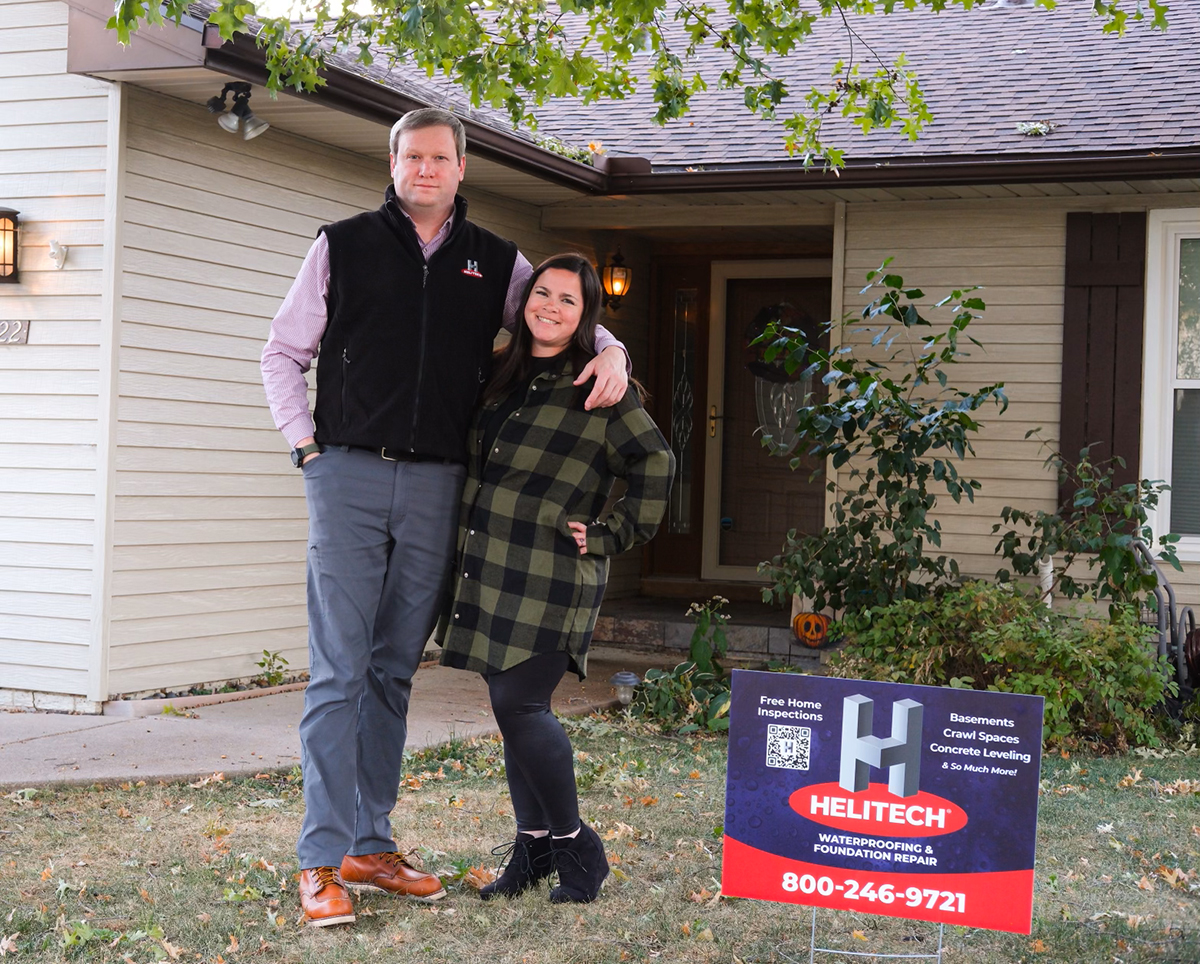 Family in front of house and helitech sign